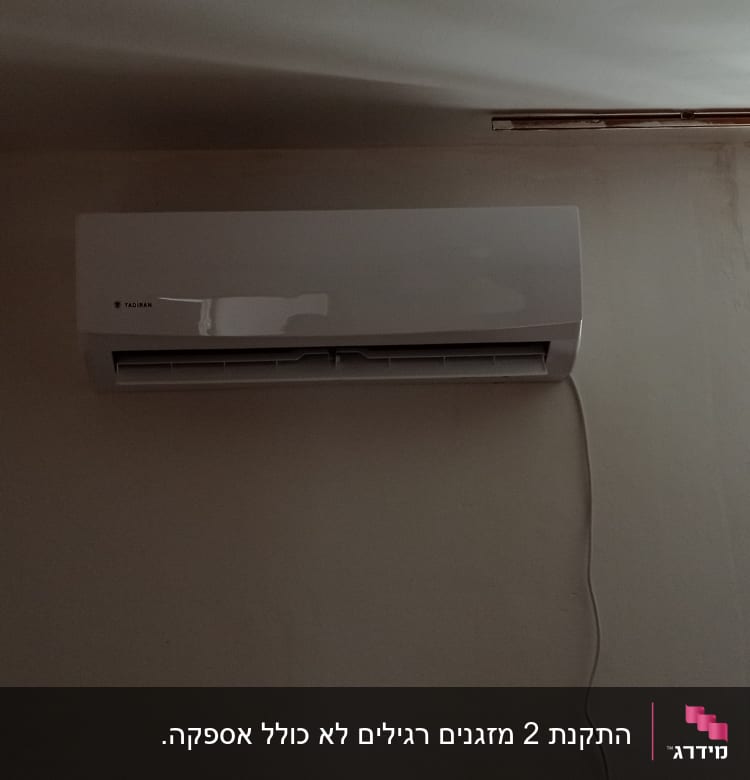 מזגן מותקן על קיר עם כבל חשמל תלוי